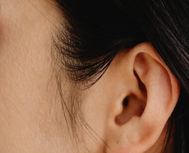 Detailed close-up photo showcasing a human ear with dark hair.