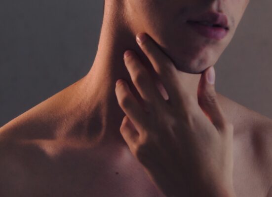 topless woman with left hand on her chin